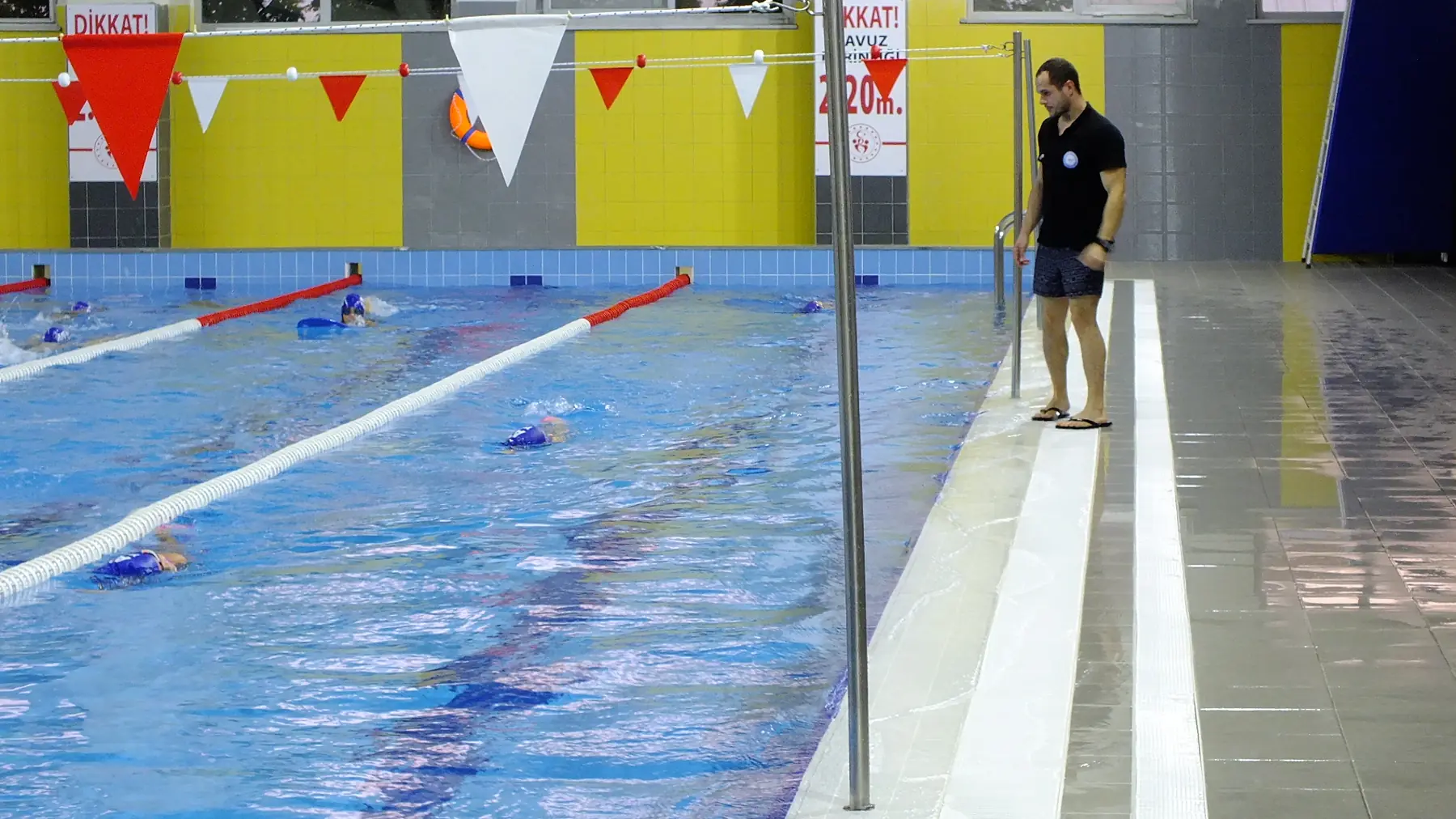 Ata Swimming coach follows the training from the poolside