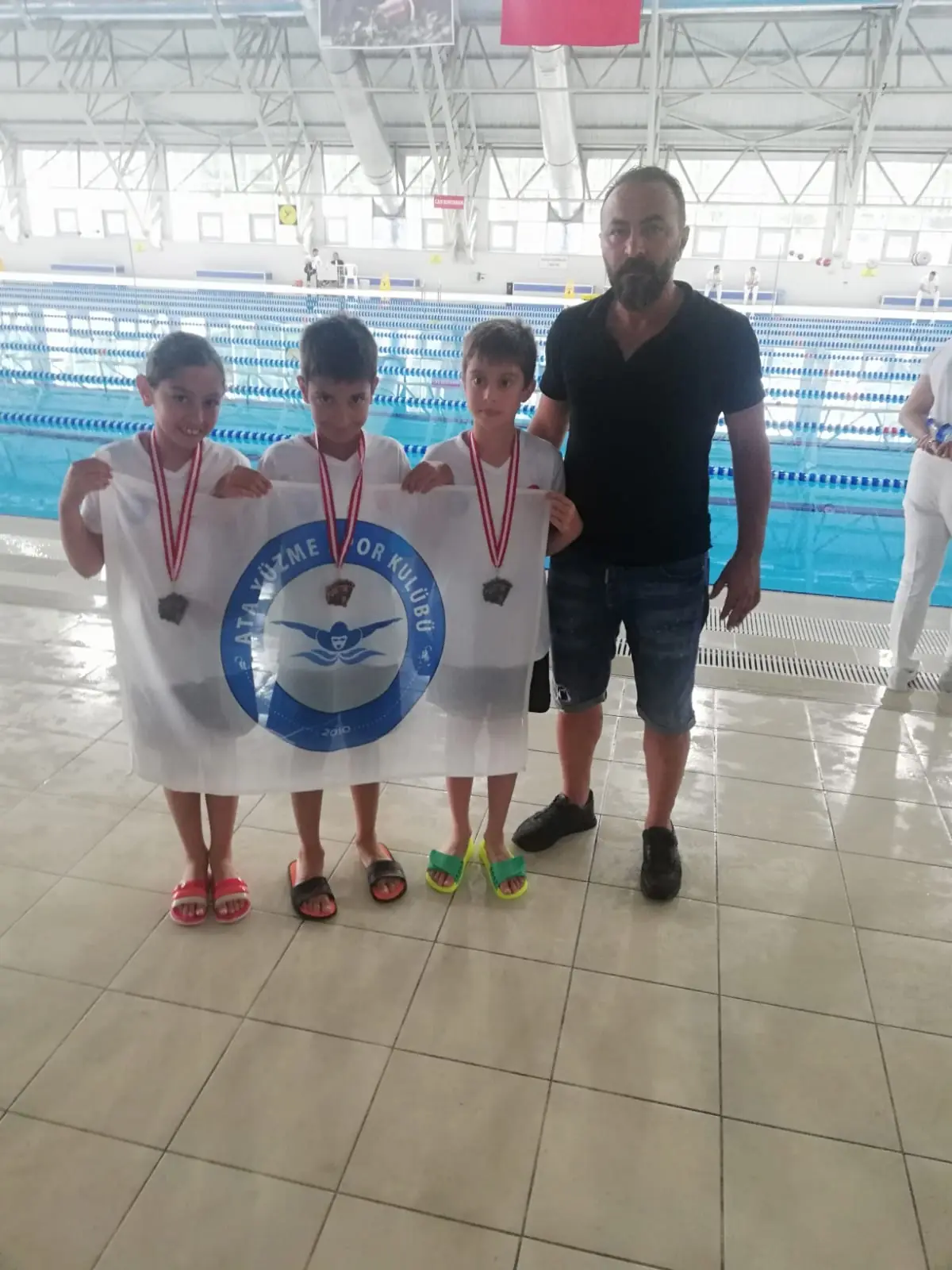 Medal-winning little athletes with their coaches