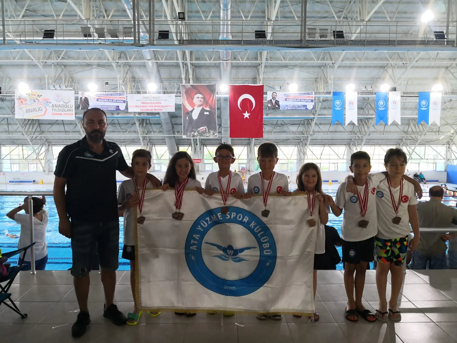Madalyalı Ata Yüzme sporcuları kulüp bayrağıyla