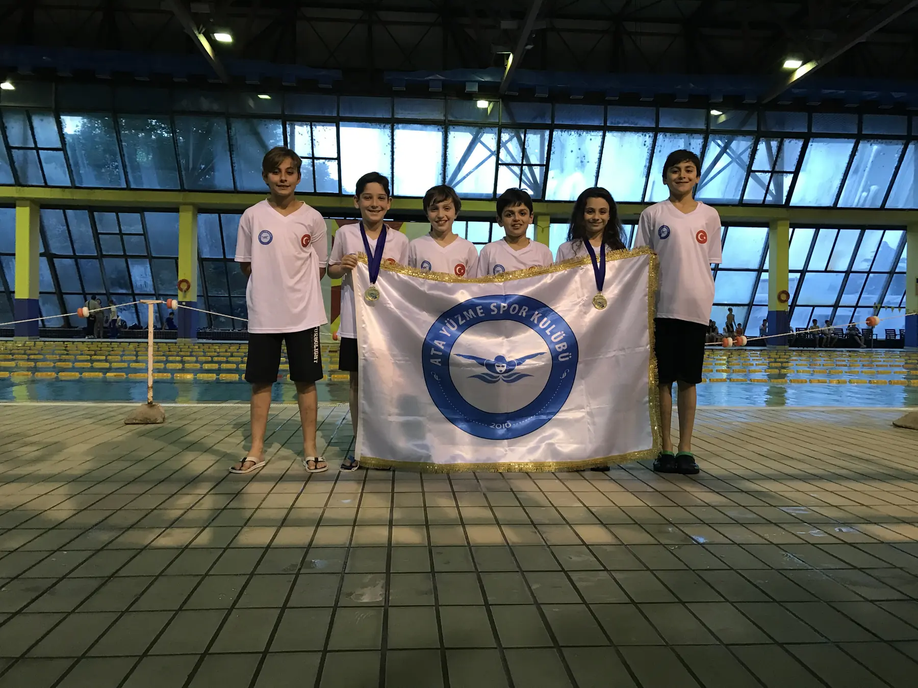 Athletes and their coaches with club flag