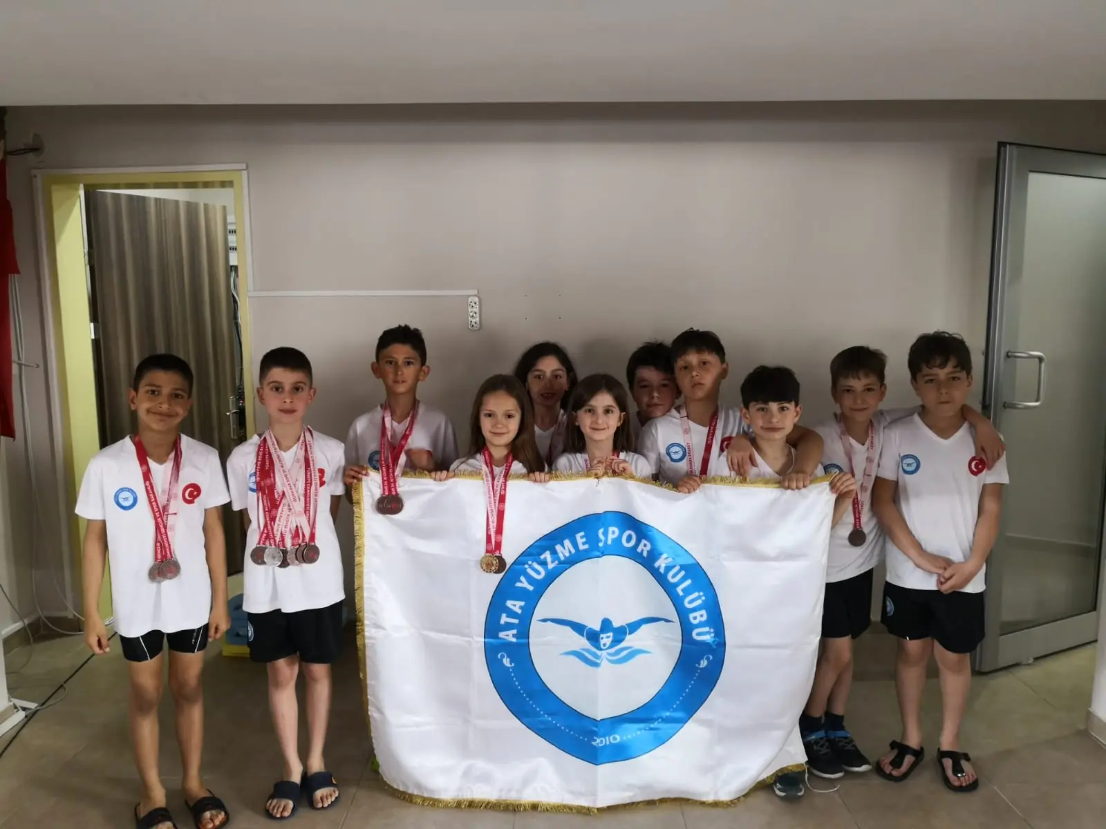 Medal-winning athletes with club flag